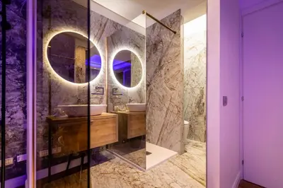 a bathroom with two sinks and two mirrors at Lyo Sky Rooms in Rome