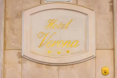 a sign on a wall with the name of a hotel karma at Hotel Verona Rome in Rome