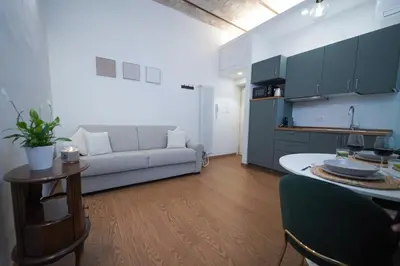 a kitchen and a living room with a couch and a table at Bruno Domus Colosseo in Rome