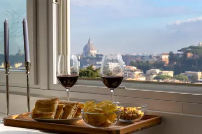a table with two glasses of wine and bread at Centrale Attico vista Magnifica sul Vaticano in Rome