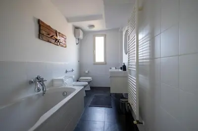 a white bathroom with a tub and a toilet at Centrale Attico vista Magnifica sul Vaticano in Rome