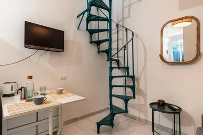 a green spiral staircase in a room with a desk at Green Central Rome Escape in Rome