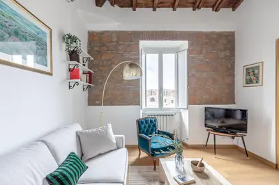 a living room with a couch and a tv at Hostly-Light and Wood Rome Midtown-Near Trevi in Rome