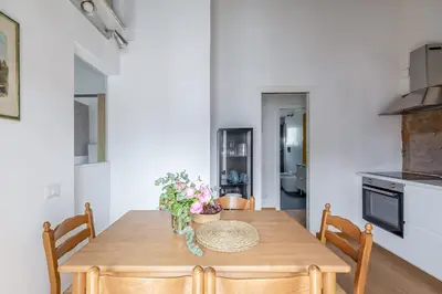 a kitchen and dining room with a wooden table and chairs at Hostly-Light and Wood Rome Midtown-Near Trevi in Rome
