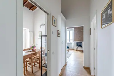 a kitchen and dining room with white walls and a table at Hostly-Light and Wood Rome Midtown-Near Trevi in Rome
