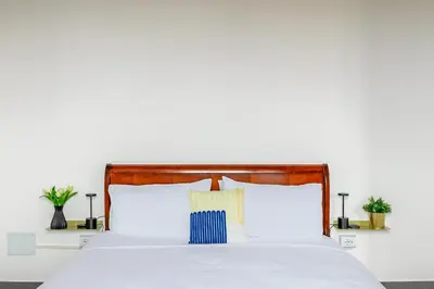 a bedroom with a white bed with two pillows at Hostly-Light and Wood Rome Midtown-Near Trevi in Rome