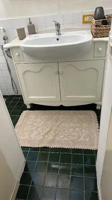 a bathroom with a white sink and a rug at Retroflatsanlorenzo in Rome