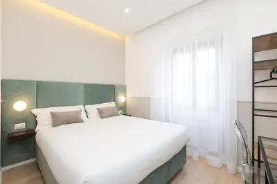a bedroom with a large white bed and a window at Vatican Colors Rooms in Rome