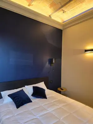 a bedroom with a white bed with a black wall at Train Station in Rome