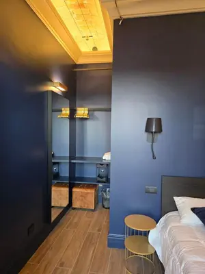 a bedroom with blue walls and a bed and a table at Train Station in Rome