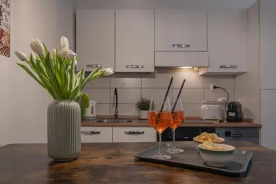 a table with two wine glasses and a vase with flowers at B&F Home Vatican Stay in Rome