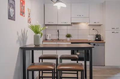 a kitchen with a table with stools and a sink at B&F Home Vatican Stay in Rome