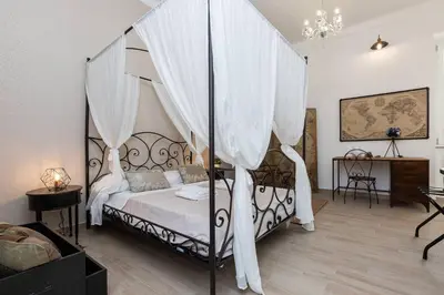 a bedroom with a canopy bed with white curtains at Iron Apartment Santa Maria in Rome