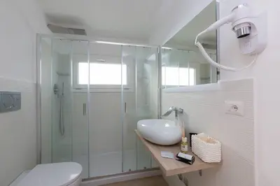 a bathroom with a shower and a toilet and a sink at Iron Apartment Santa Maria in Rome