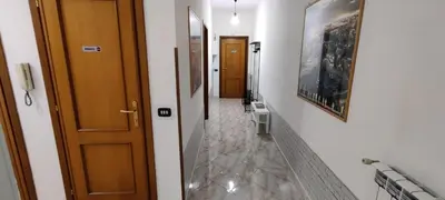 a hallway with two doors and paintings on the walls at Malagrino House in Rome