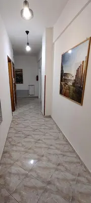 a hallway with a tile floor and a painting on the wall at Malagrino House in Rome