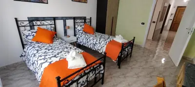 two beds in a room with orange and white at Malagrino House in Rome