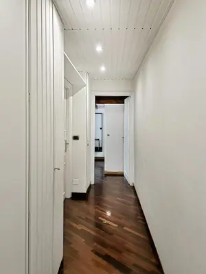 an empty hallway with white walls and wood floors at Domus Trevis in Rome