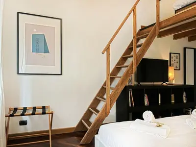 a bedroom with a staircase with a bed and a television at Domus Trevis in Rome