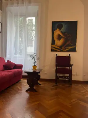 a living room with a red couch and a painting at Vintage In Rome in Rome