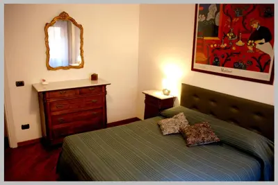a bedroom with a bed and a dresser and a mirror at Holiday Rome Apartment in Rome