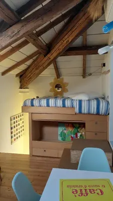 a room with a bunk bed with a table and chairs at Loft at Ponte Milvio in Rome