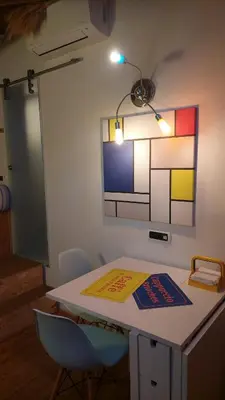 a room with a table with chairs and a painting on the wall at Loft at Ponte Milvio in Rome