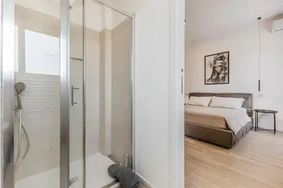 a bedroom with a bed and a glass shower at Domus Urbe Piramide in Rome