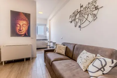 a living room with a couch and a painting on the wall at Domus Urbe Piramide in Rome