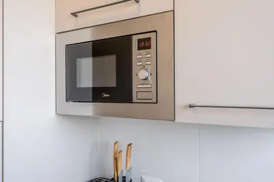 a microwave hanging above a kitchen counter at Domus Urbe Piramide in Rome