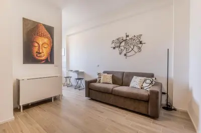 a living room with a couch and a painting on the wall at Domus Urbe Piramide in Rome