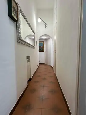 a long hallway with a mirror and a tile floor at 888 Vittorio in Rome