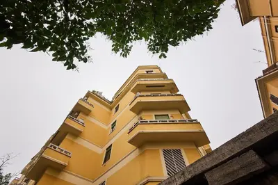 a tall yellow building looking up into the sky at Superior Vatican suite Key Apartment in Rome