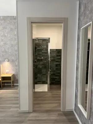a hallway with a door leading to a bathroom at Tiburtina Urban Rooms in Rome