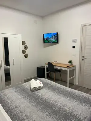 a bedroom with a bed with a desk and a computer at Tiburtina Urban Rooms in Rome