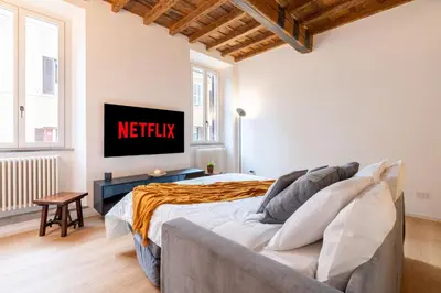 a bedroom with a bed and a tv on the wall at Sotto al letto del Papa - Borgo Pio - Vaticano in Rome