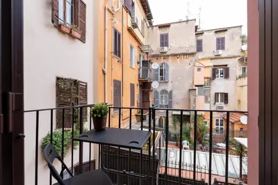 a balcony with a table and a view of buildings at Sotto al letto del Papa - Borgo Pio - Vaticano in Rome