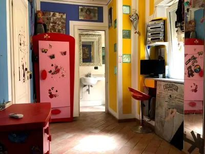 a bathroom with a pink refrigerator and a sink at A casa di Simone in Rome