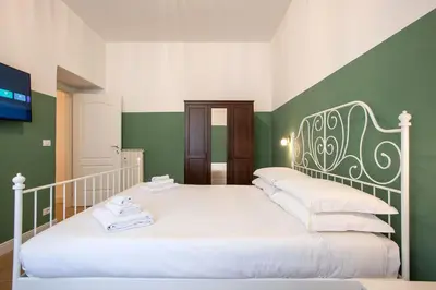 two beds in a room with green and white walls at Design Home - Vicino il centro in Rome
