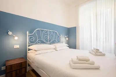 a bedroom with a large white bed with blue walls at Design Home - Vicino il centro in Rome