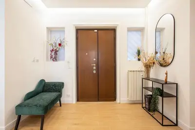 a hallway with a green chair and a brown door at Design Home - Vicino il centro in Rome