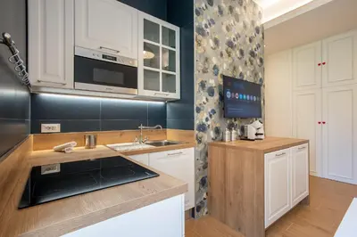 a kitchen with white cabinets and a sink at Design Home - Vicino il centro in Rome