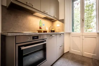a kitchen with white cabinets and an oven at Aradam Luxury Heritage in Rome