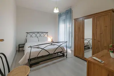 a bedroom with a bed and a desk and a mirror at Delightful Tourist Apartment in Rome