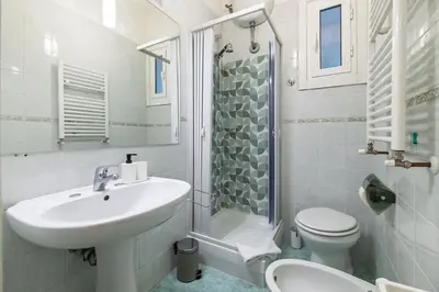 a white bathroom with a sink and a toilet at Delightful Tourist Apartment in Rome