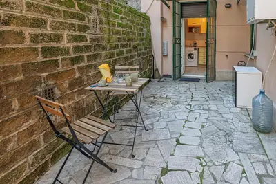 a patio with a table and chairs and a brick wall at Delightful Tourist Apartment in Rome