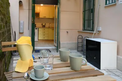 a wooden table with cups and glasses on a patio at Delightful Tourist Apartment in Rome