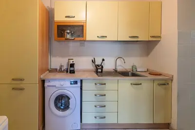 a kitchen with a washing machine and a sink at Delightful Tourist Apartment in Rome