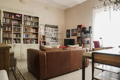 a living room with a couch and book shelves at Casa Mau - Vacation Vibes in Rome
