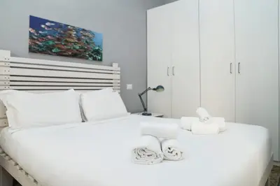 a white bedroom with two beds with white pillows at Casa Mau - Vacation Vibes in Rome